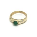 An 18carat gold ring set with an emerald and caboc