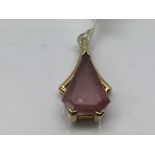 A 9ct gold pendant set with a red atone in triangu