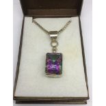 A silver cased multicoloured gemstone pendant on a