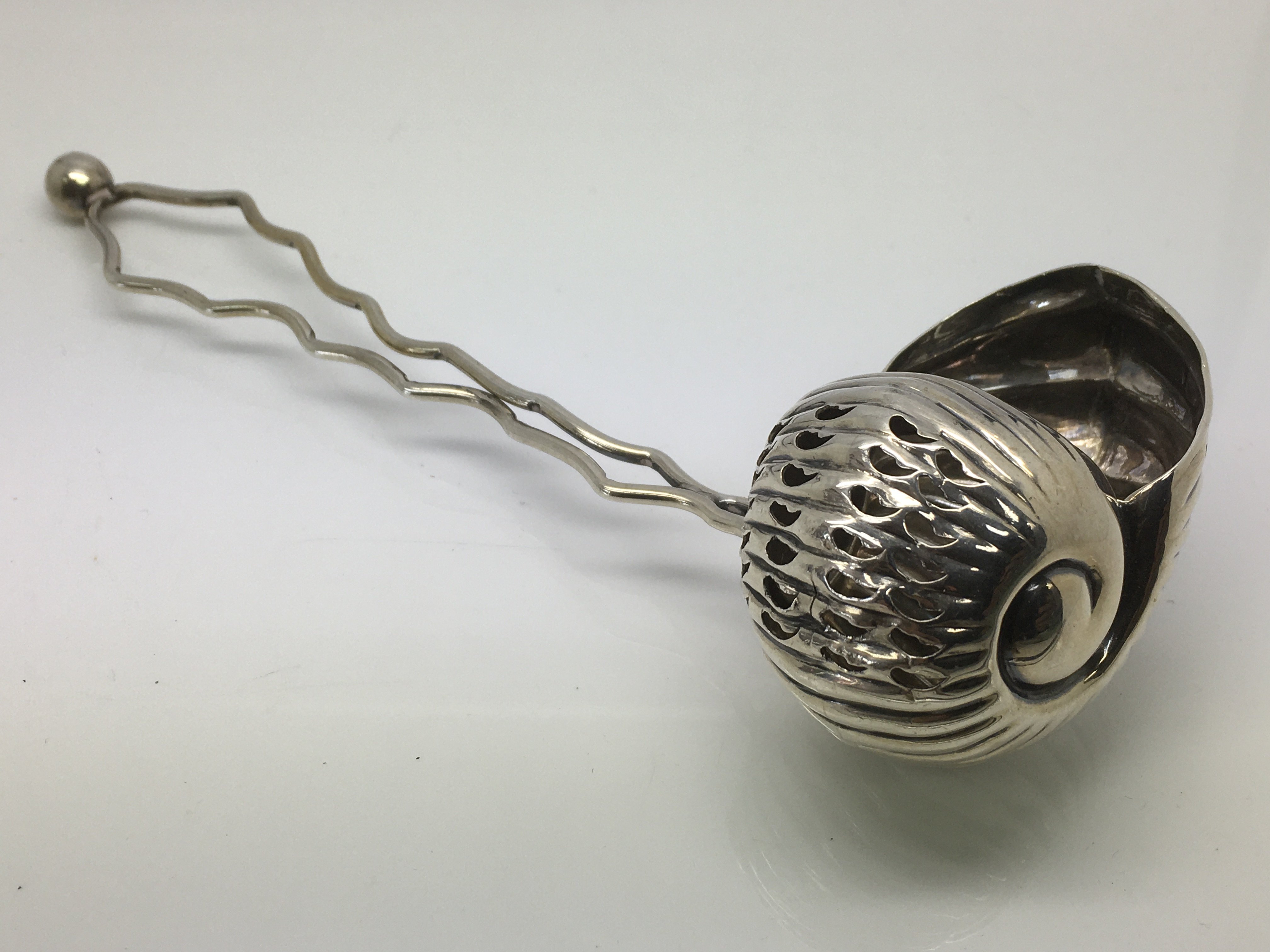 A silver sugar sifter by Cooper & Son in the form