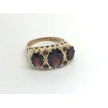 A 9carat gold ring set with three garnets ring siz