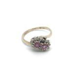 An 18ct gold ruby and diamond ring with twin flowe