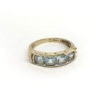 A 9carat gold ring set with four aquamarine coloured stones ring size O