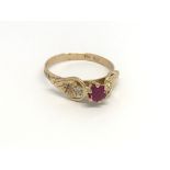 An 18carat gold ring set with a ruby flanked by two diamond. ring size M