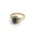 An 18carat gold ring set with a sapphire flanked by an oval of diamonds ring size K