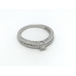 A 9ct white gold solitaire diamond ring with furth