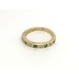 An 18carat gold ring set with emeralds and diamond