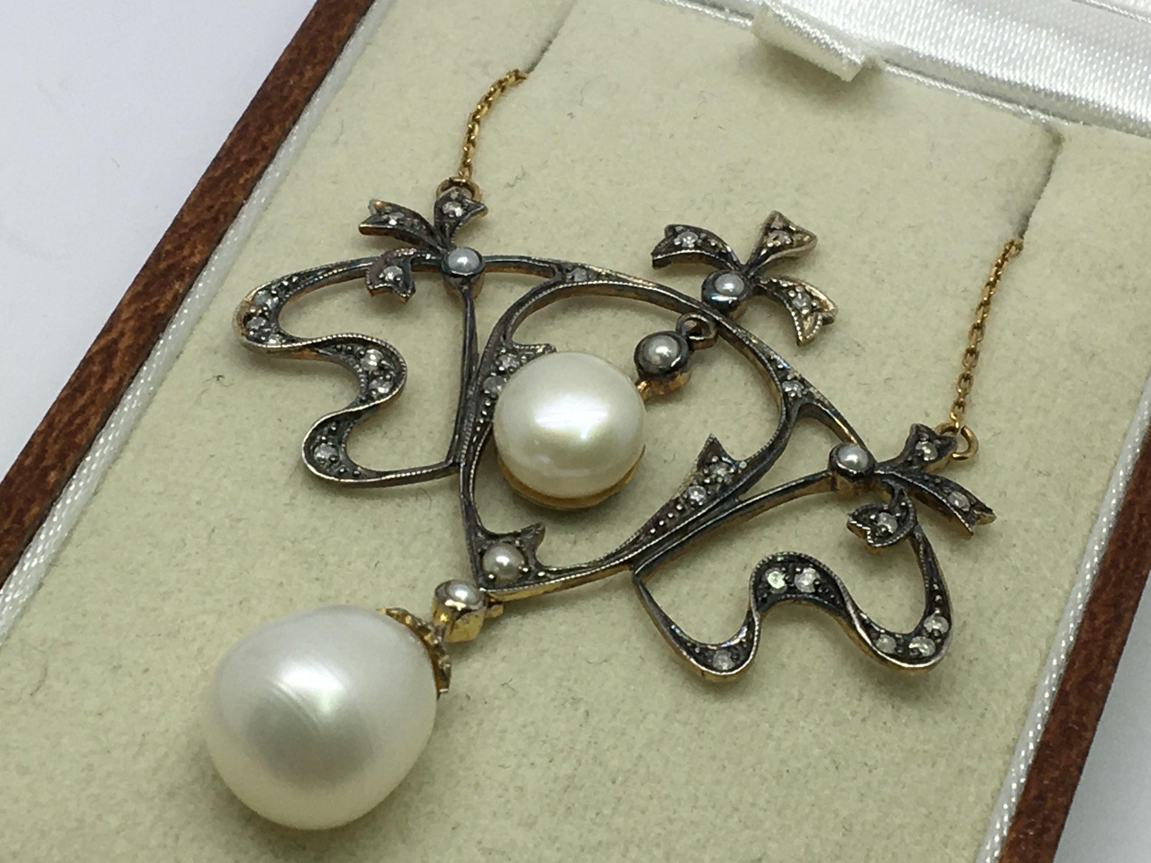 A necklace set with diamonds, pearls and seed pear