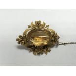 A unmarked Victorian brooch set with large cut citrine surrounded by a fancy foliate mount, 4 cm.