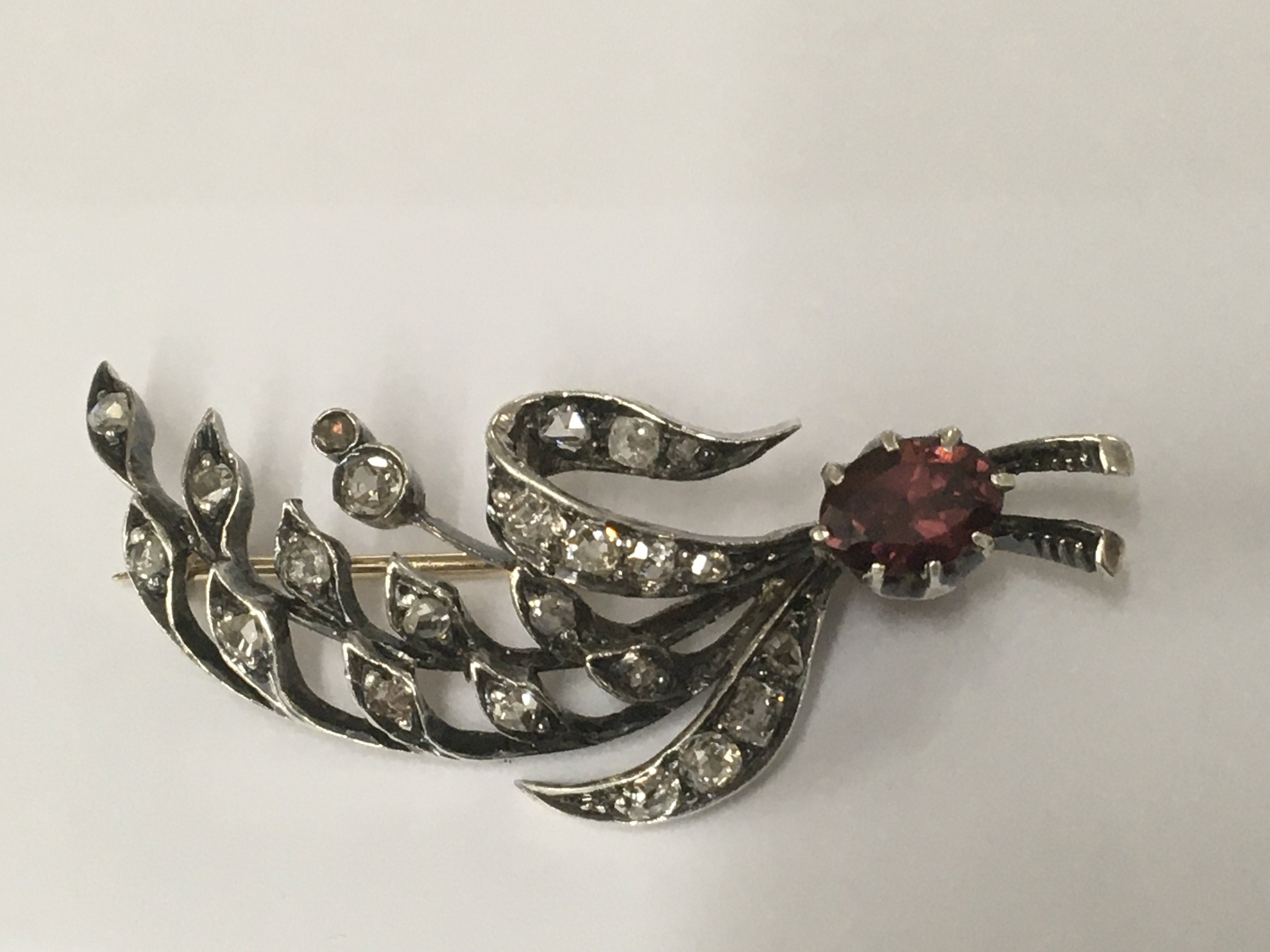An antique brooch in the form of a spray of flower