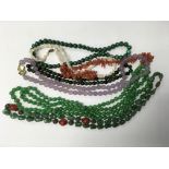 A silver gilt clasped string of hard stone beads p