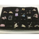 A display case containing 17 silver rings , some s