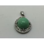 A 9ct white gold pendants set with a central green