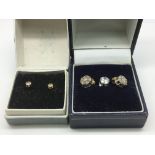 Two pairs of earrings set with clear stones plus o
