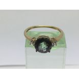 A 9ct gold ring set with a central green stone, ap