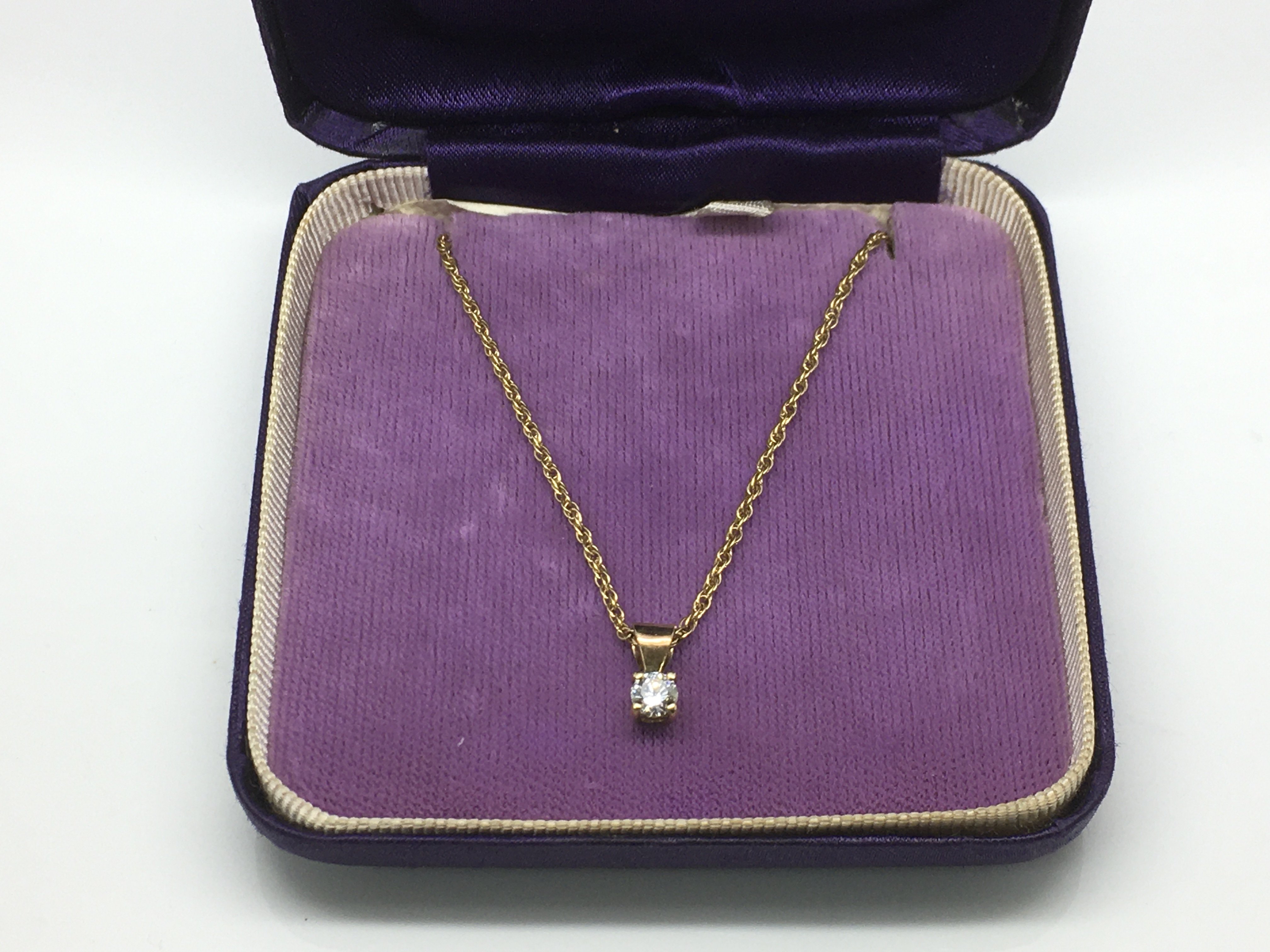 A diamond pendant on a 9ct gold chain, approx 1/4c