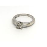 An 18carat white gold ring set with a square pattern of four diamond total carat weight