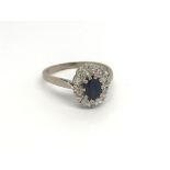 An 18carat gold ring set with a central deep blue blue sapphire approx 0.50 of a carat flanked by an