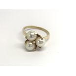 An 18carat gold ring set with three cultured pearl