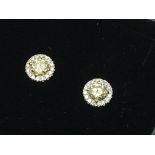 A pair of 18ct white gold yellow diamond halo stud