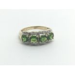 A 9carat gold ring set with four Oval cut green st