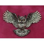 A large Butler & Wilson stone set brooch in the form of an owl with outstretched wings.