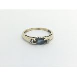 A 9carat gold ring set with a sapphire flanked by