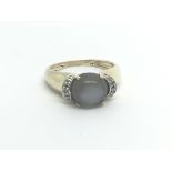 A 9carat gold ring set with moon stone flanked by