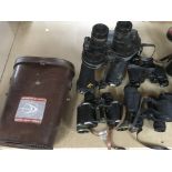 A collection of binoculars including military.