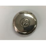 A circular silver tobacco box, the lid inset with