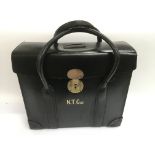 A black leather holdall printed N.T. Gas (North Thames Gas?) to the front in gold coloured letters.