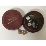 A leather stud case contacting studs and cufflinks