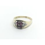 A 9carat gold ring set with a pattern of ruby and diamonds. ring size O.