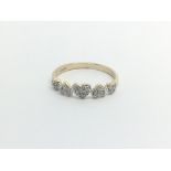 A 9carat gold ring set with a pattern of five heart shaped diamond clusters. Ring size N.