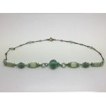 An antique metal and glass bead necklace in a Harr