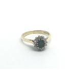 An 18carat gold ring set with an Emerald flanked b
