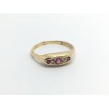 An 18carat gold ring set with three ruby and diamo