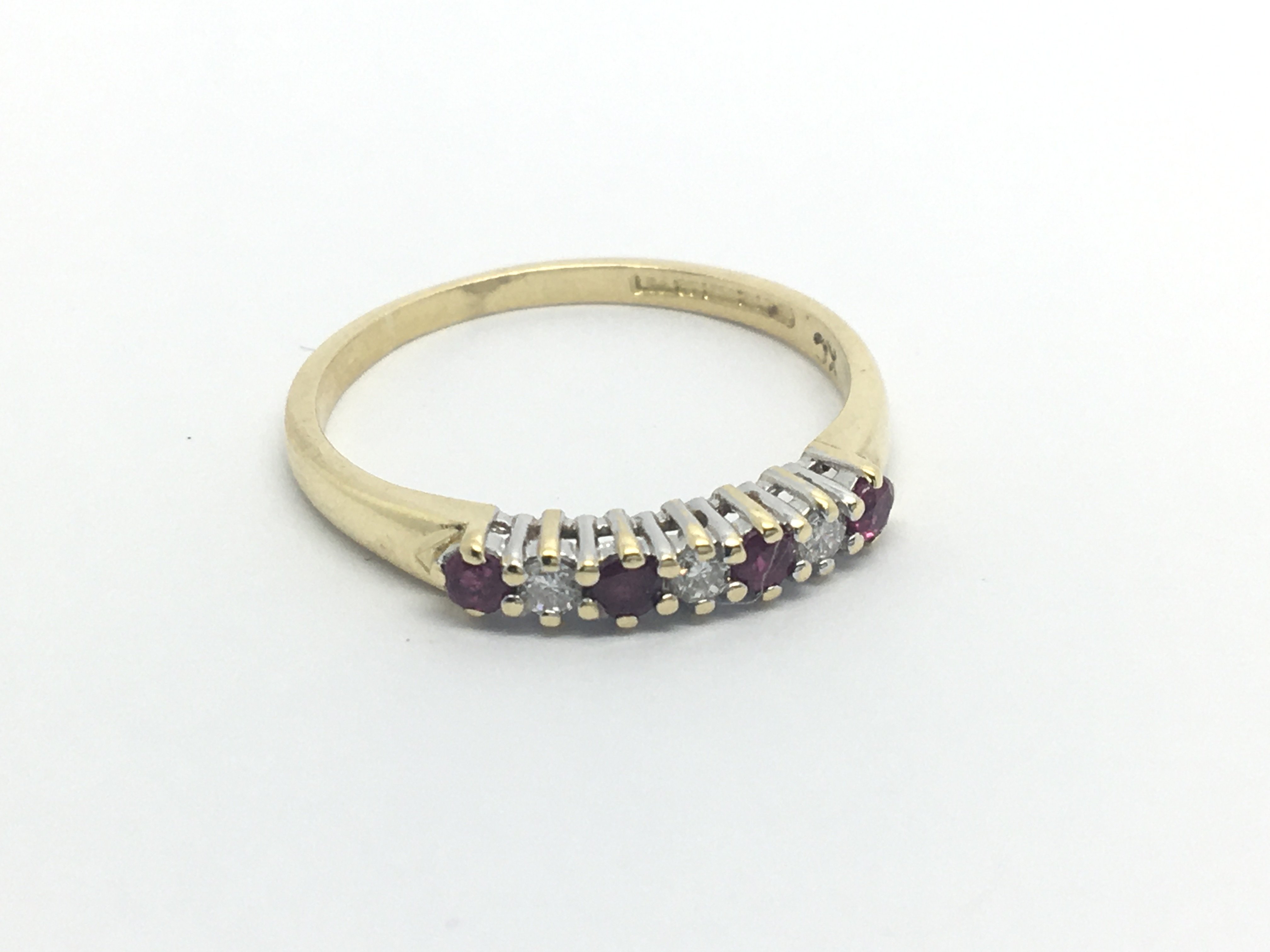 An 18carat gold ring set with an alternating row of ruby and diamonds ring size O