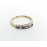 An 18carat gold ring set with an alternating row of ruby and diamonds ring size O