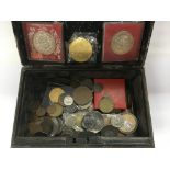 A vintage money tin containing old coins and token