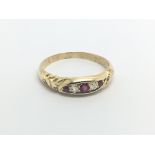 An 18carat gold ring set with a row of ruby and diamonds ring size T-U