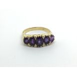 An 18carat gold ring set with a row of Amethyst st