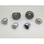Six silver rings set with stones.