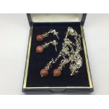 A silver and goldstone necklace and matching earrings.