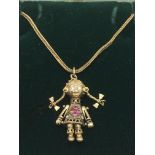 A 9ct gold chain with an articulated pendant of a girl with pigtails and inset with stones, approx