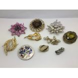 Ten vintage costume brooches including an enamel e