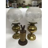 Two brass oil lamps and an iron string holder with