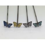 Four antique silver and enamel butterfly hatpins.