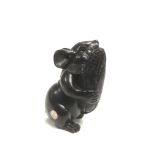 A carved and ebonised netsuke of a mouse holding a