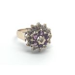 A 9carat gold ring set with a cluster pattern of almandine garnets and diamonds ring size O.